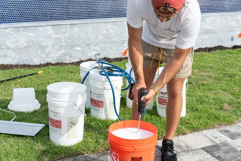 A crew member mixing sealer in a bucket before application
